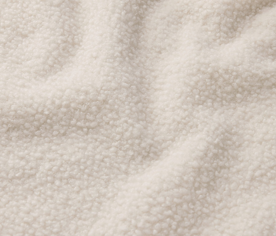 Gros plan sur un tissu en peau lainée crème.