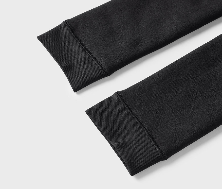 Détail de deux manches noires de sweat-shirt avec poignets côtelés.
