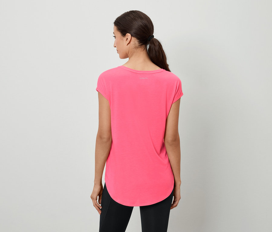 Une femme aux cheveux bruns attachés en queue de cheval se tient dos à la caméra et porte un t-shirt rose et un legging noir.