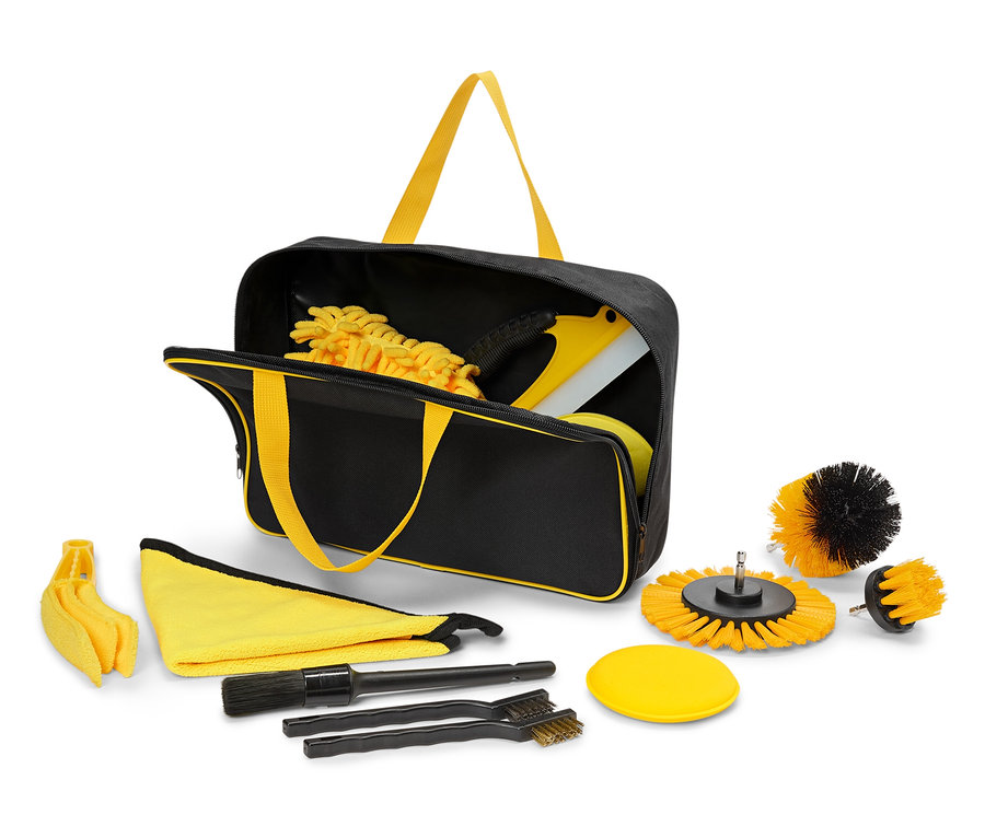 Un sac noir avec des poignées jaunes contient et entoure un ensemble d'outils de nettoyage.