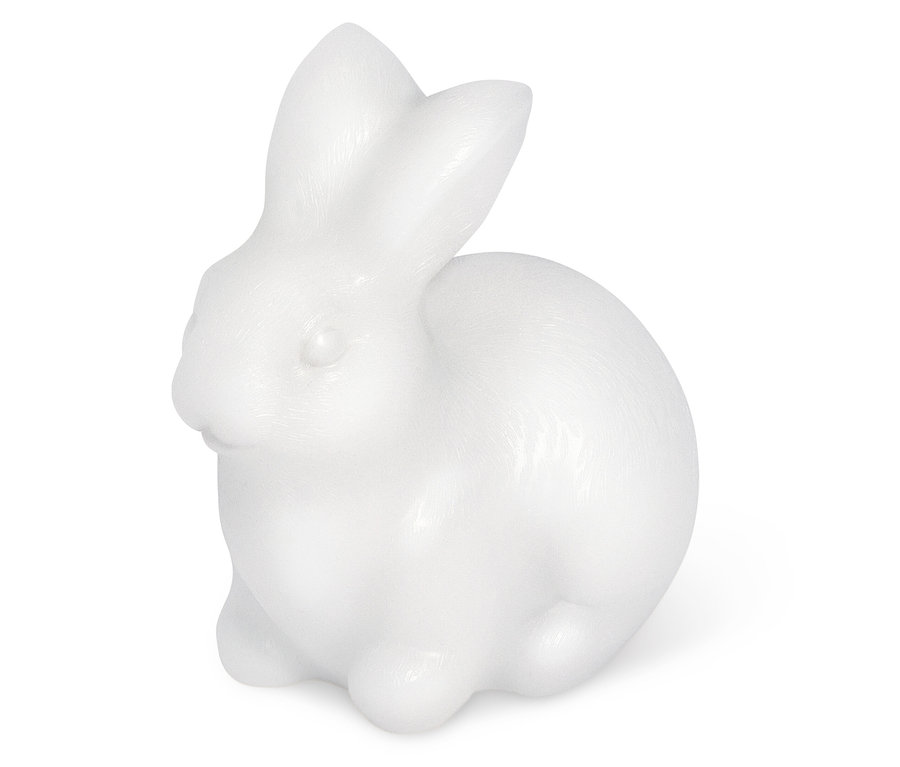 Une figurine de lapin blanche assise sur un fond blanc.
