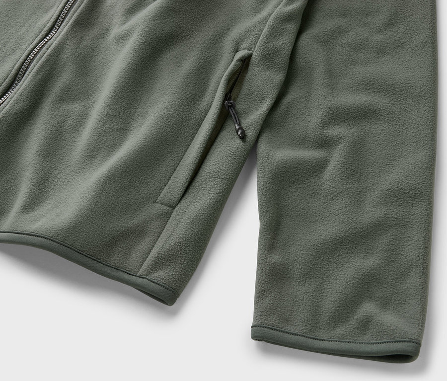 Gros plan sur une veste polaire kaki avec fermeture éclair et poche.
