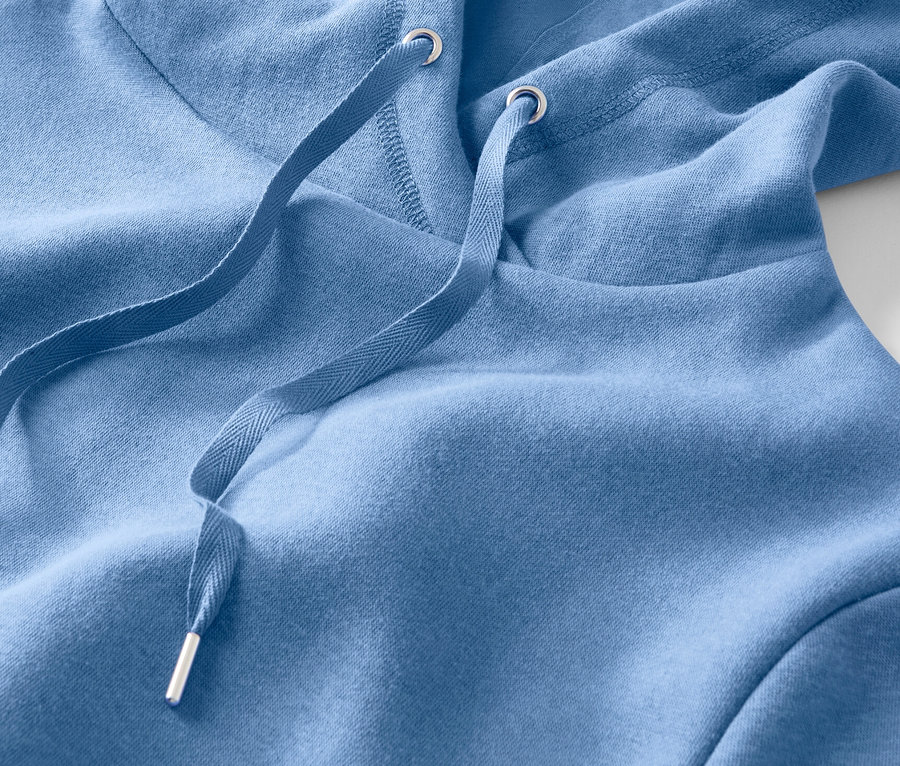 Gros plan sur un sweat à capuche bleu clair avec cordon de serrage.