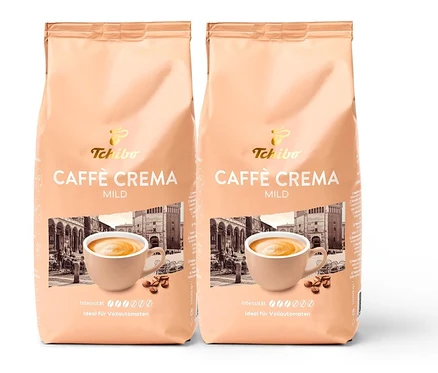 Deux paquets de Caffè Crema Mild en grains – 2x 1 kg de Tchibo. L'emballage montre une tasse de café et un bâtiment.