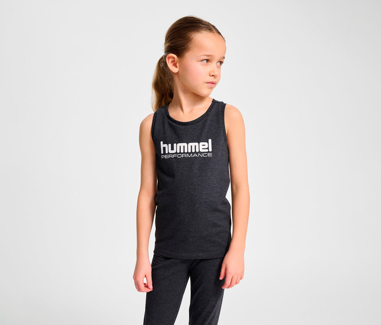 Une fille porte un débardeur gris HUMMEL HMLJR Top.