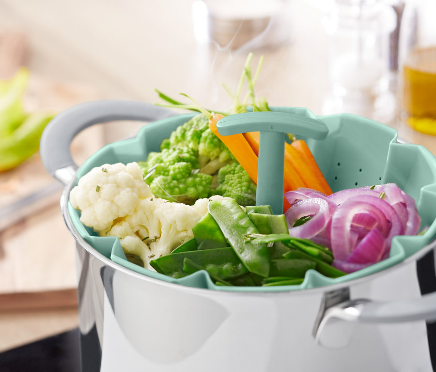 Légumes dans un panier vapeur au-dessus d'une casserole.