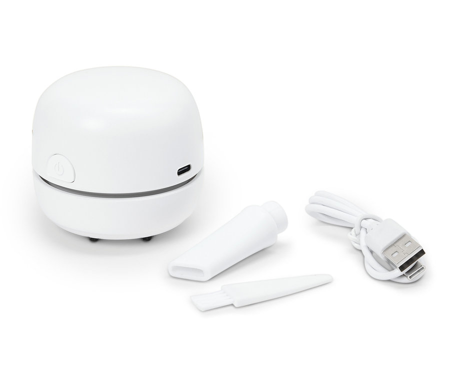 Un mini aspirateur blanc avec des accessoires et un câble USB.