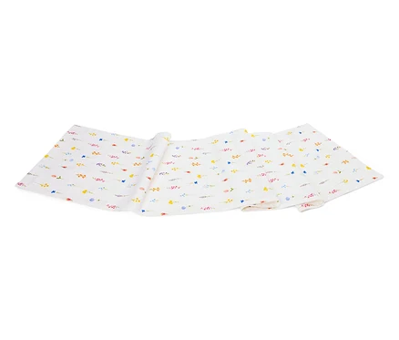 Un tissu blanc avec un motif de petites fleurs colorées est plié sur un fond blanc.