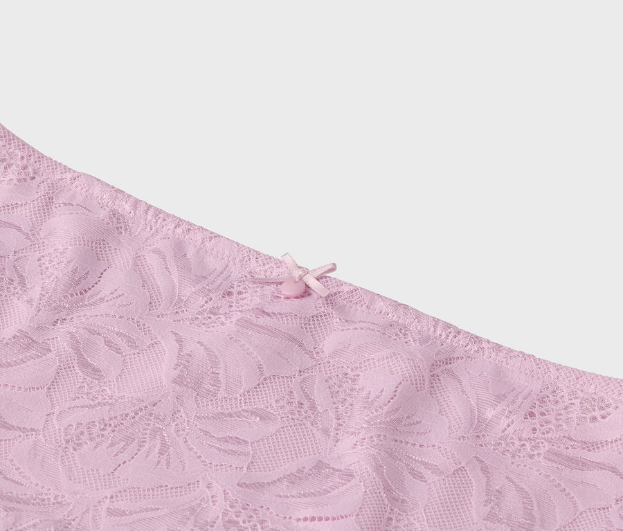 Détail d'un tissu en dentelle rose avec un nœud.