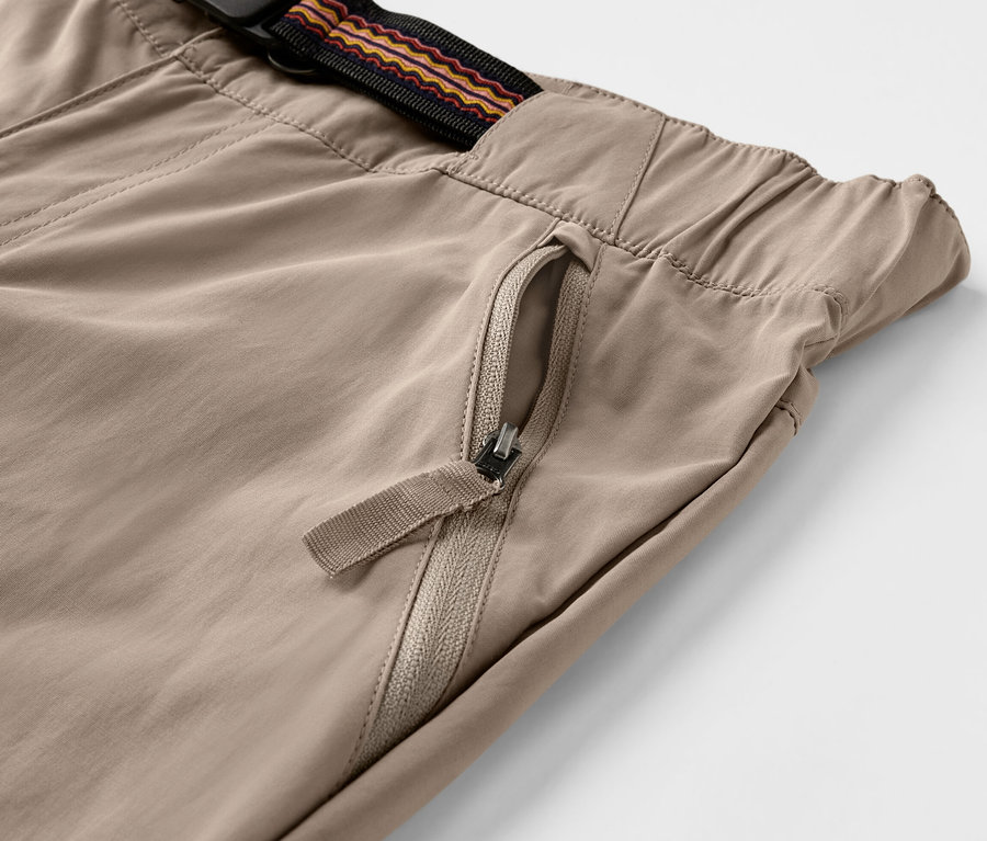 Gros plan d'un pantalon d'extérieur marron avec protection anti-moustiques et poche zippée.