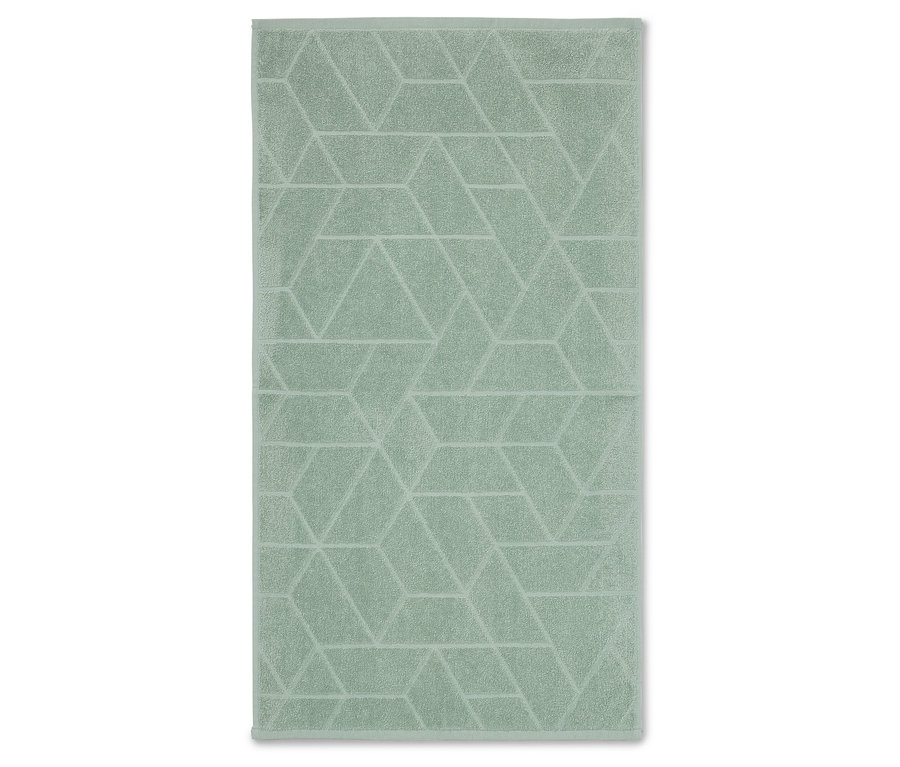 Une serviette vert clair avec un motif géométrique, posée à plat sur une surface blanche.