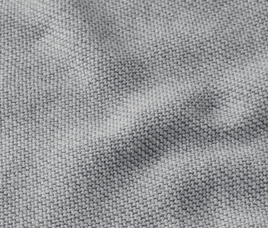 Gros plan d'un tissu tricoté gris avec de légers plis.