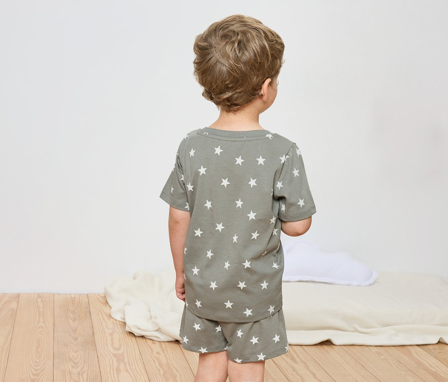 Un enfant vu de dos, portant un pyjama à motif étoilé.