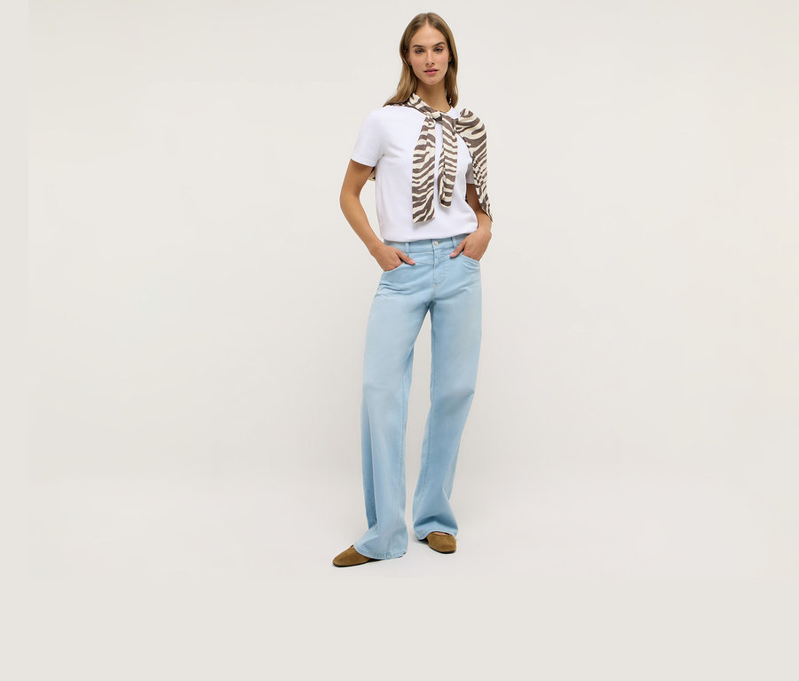Femme portant un t-shirt blanc et un jean Angels Denim « Liz Modern » à jambes larges. Un foulard à motif zébré est noué autour de ses épaules.