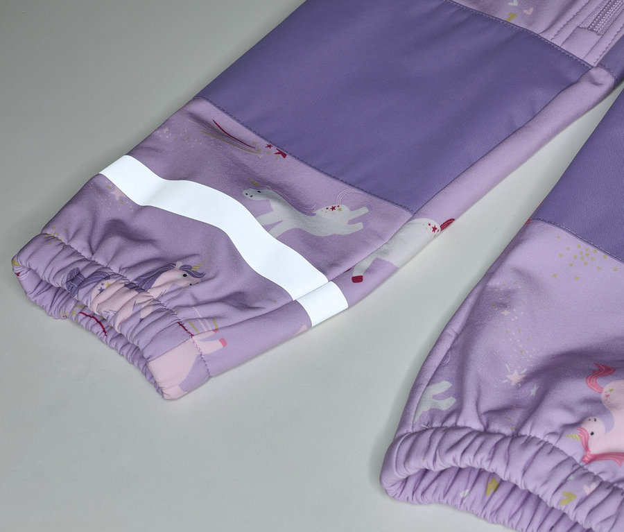 Gros plan d'un pantalon pour enfant violet avec un motif de licorne et une bande réfléchissante sur la manche.