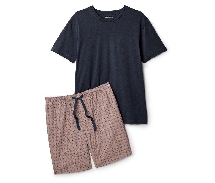 Un t-shirt bleu marine et un short rose avec un motif bleu sont posés sur un fond blanc.