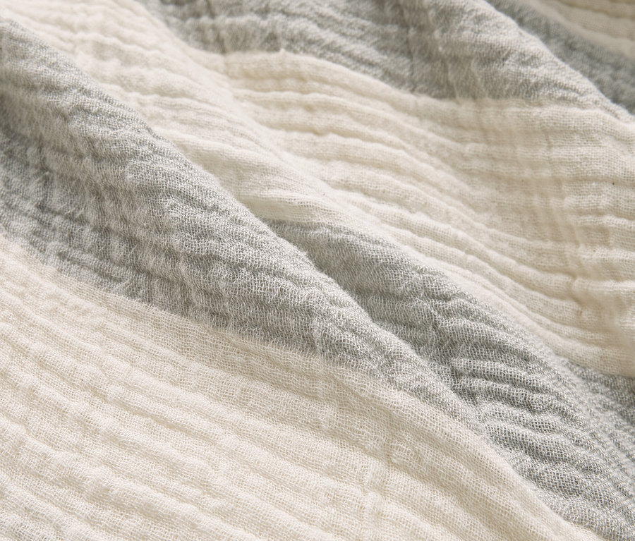 Gros plan d'un tissu à rayures grises et blanches.