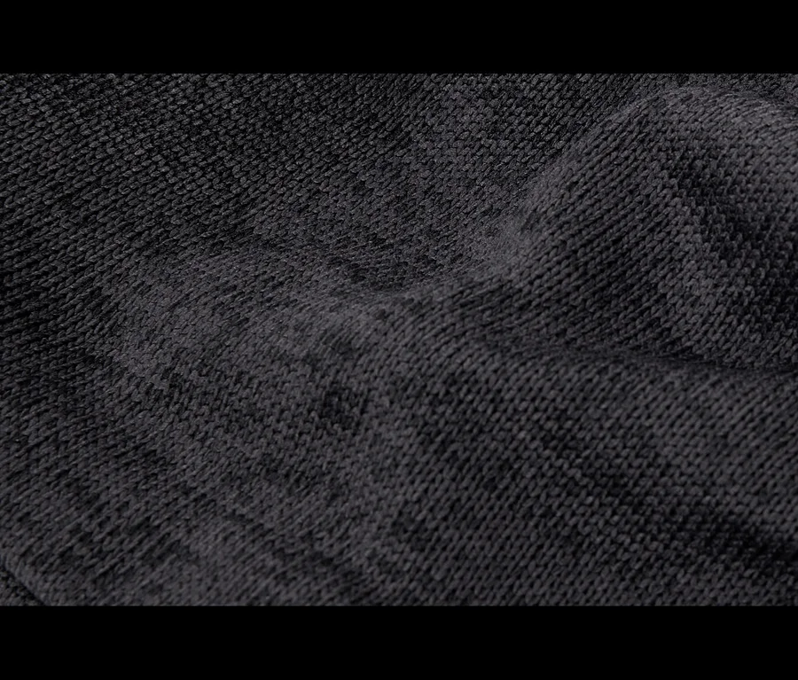 Gros plan d'un tissu tricoté gris foncé et doux, avec des plis et une texture légèrement duveteuse.