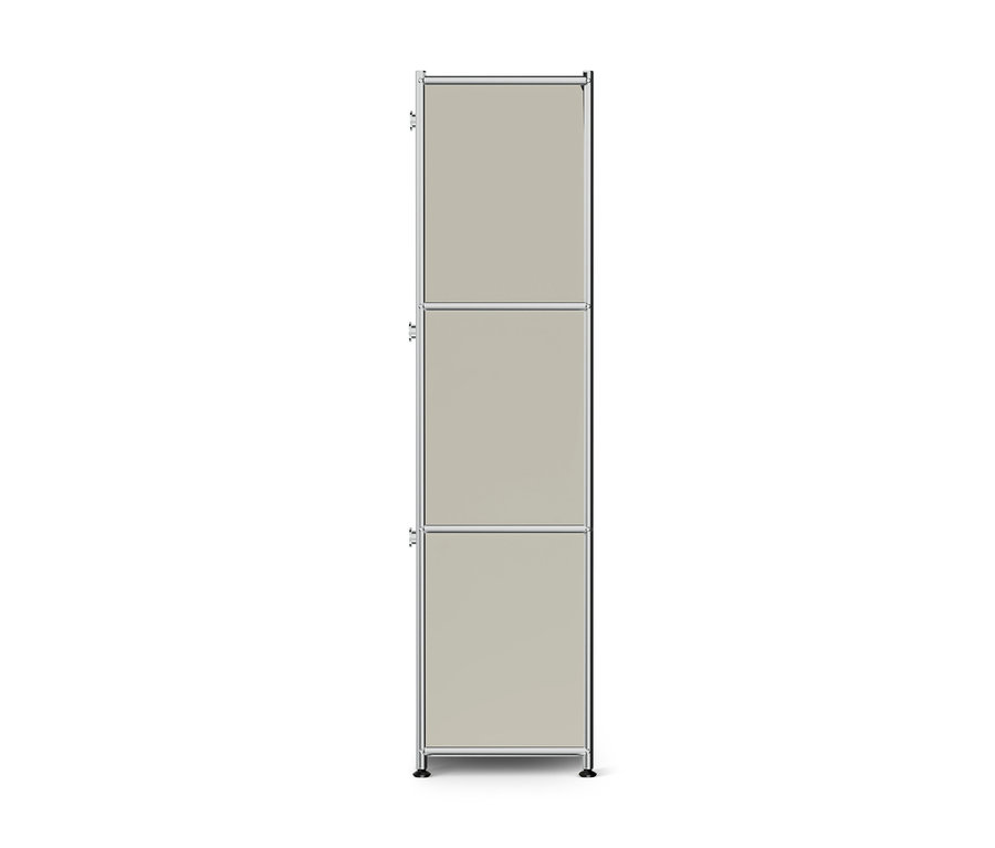 Meuble de rangement haut et étroit avec un cadre chromé et trois panneaux beige clair empilés. Chaque panneau a une petite poignée sur le côté gauche, et le meuble repose sur des pieds noirs.