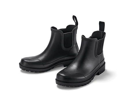 Deux bottes en caoutchouc noires sur fond blanc.