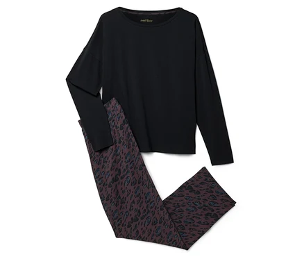 Un haut noir à manches longues et un pantalon marron foncé avec un motif léopard bleu et noir, posés à plat sur un fond blanc.