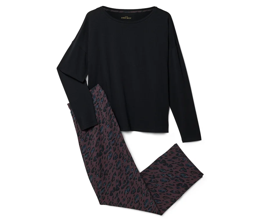 Un haut noir à manches longues et un pantalon marron foncé avec un motif léopard bleu et noir, posés à plat sur un fond blanc.