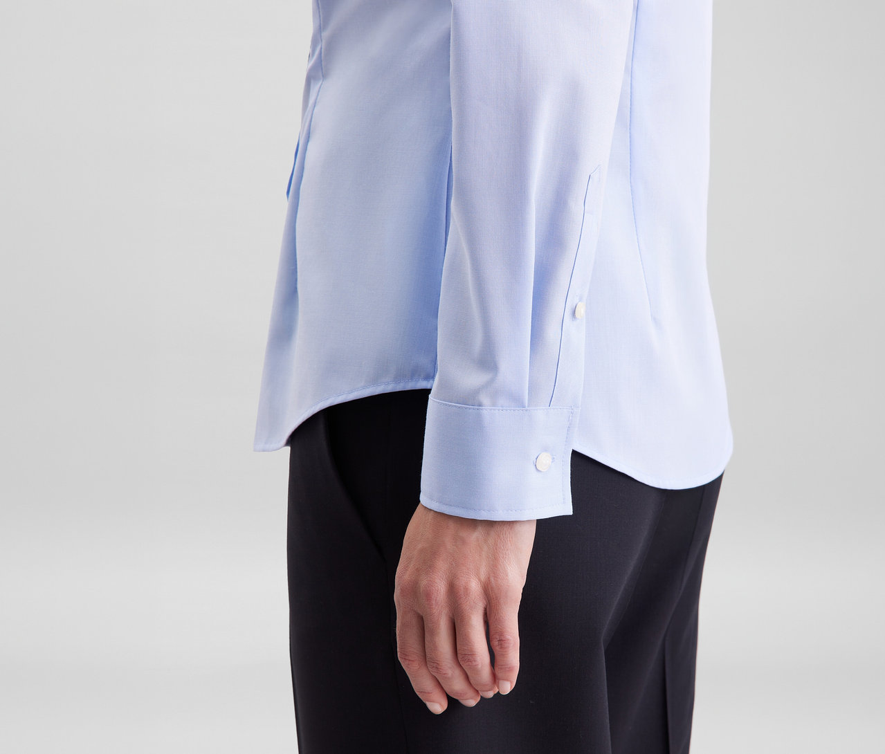Personne portant un chemisier Slim Fit non iron Seidensticker bleu clair et un pantalon noir.