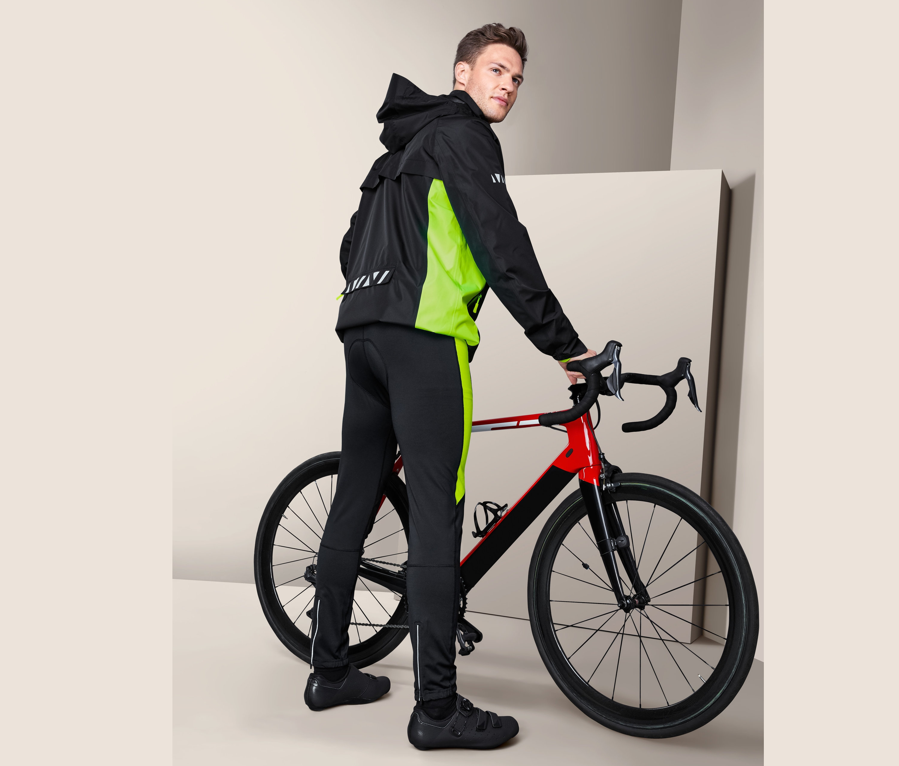 Un homme pose à côté d'un vélo en portant un pantalon de vélo.