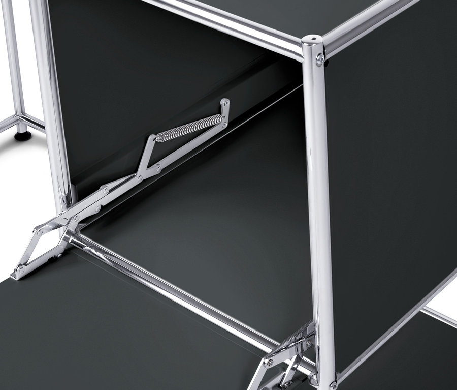 Détail du bureau en métal noir « CN3 » avec porte abattante et structure chromée.
