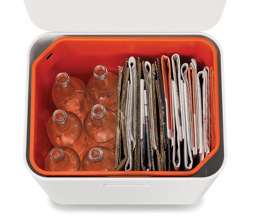 Vue de dessus d'une poubelle de tri sélectif Joseph Joseph remplie de bouteilles en verre et de papier.