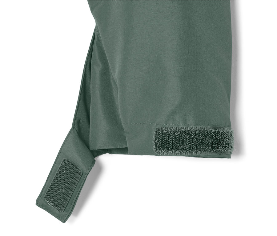 Gros plan sur une veste pour tous les temps verte avec une fermeture velcro sur la manche.