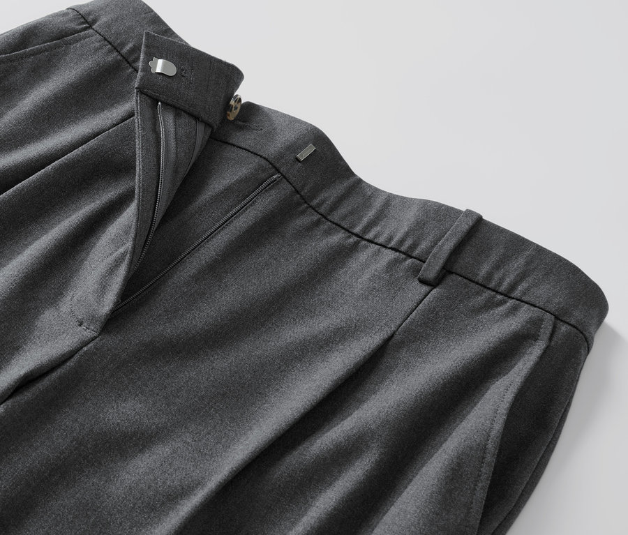 Gros plan sur un pantalon tissé confortable gris avec une fermeture éclair ouverte.