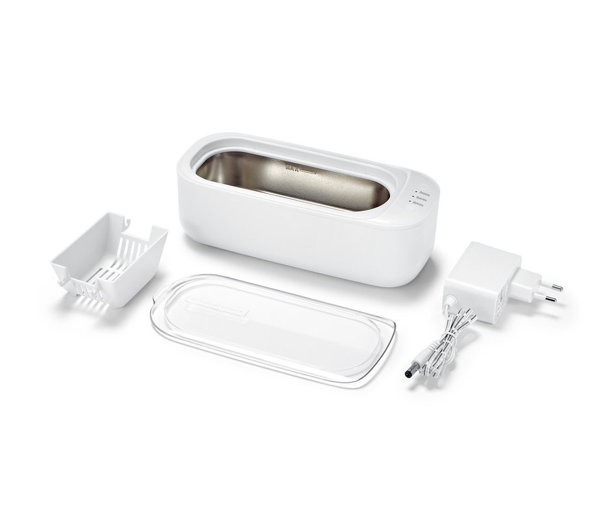 Un nettoyeur à ultrasons et ses accessoires sur un fond blanc.