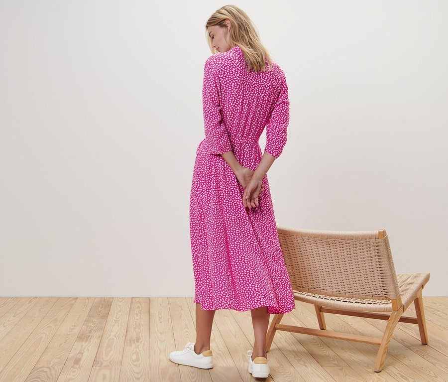 Une femme, vue de dos, porte une robe chemise imprimée.