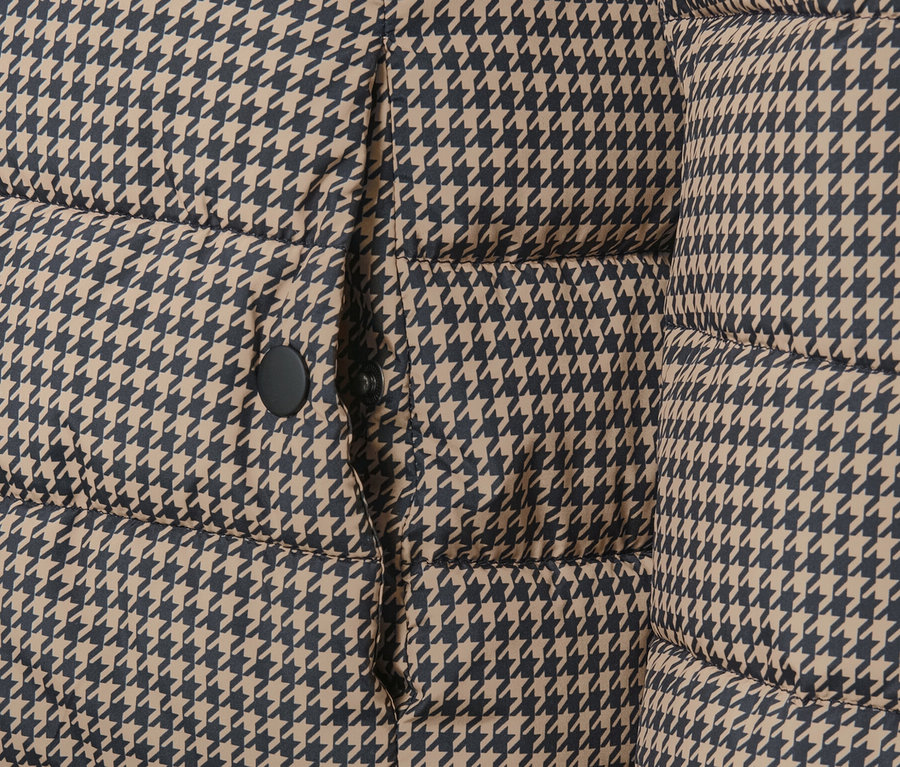 Gros plan sur une veste matelassée imprimée avec capuche à motif pied-de-poule.