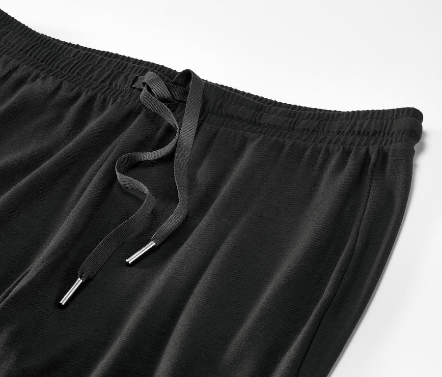 Gros plan sur un pantalon de pyjama noir avec cordon de serrage à la taille.