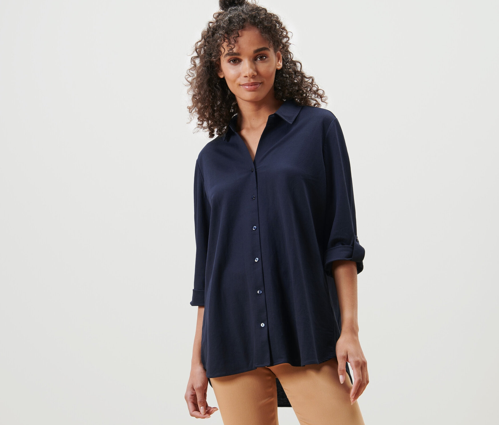 Femme posant dans un chemisier en jersey piqué bleu foncé.