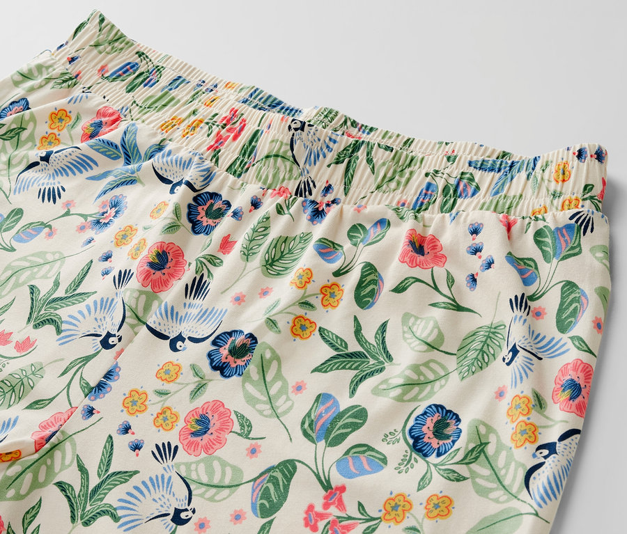 Gros plan sur un ensemble pyjama avec motif floral et oiseau.