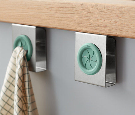 Deux porte-torchons de cuisine fixés sur une armoire grise sous un comptoir en bois.
