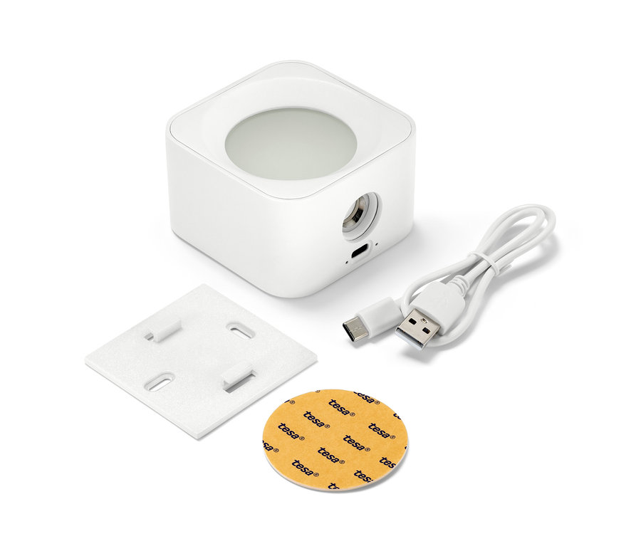 Une applique murale LED blanche à batterie, une plaque de montage, un câble de chargement et une surface adhésive sur fond blanc.