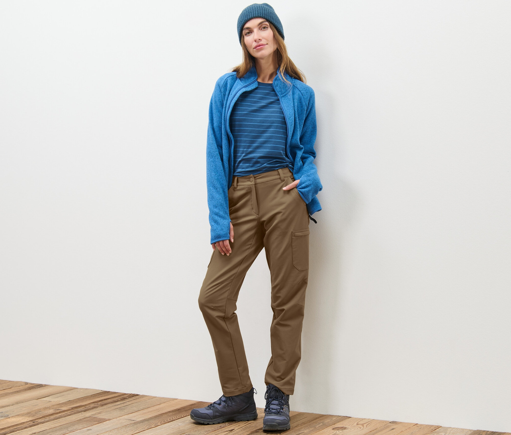 Une femme debout porte un pantalon cargo en softshell beige.