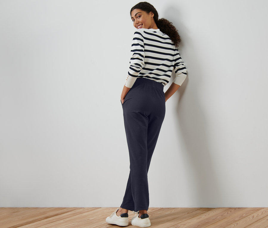 Femme posant en pantalon de jogging bleu marine.