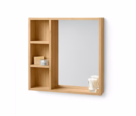 Miroir avec étagères en bambou clair. Du savon et une boîte sont sur une étagère, des cotons-tiges dans un verre sur l'étagère inférieure.