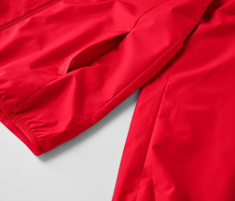 Détail d'une veste technique coupe-vent rouge.