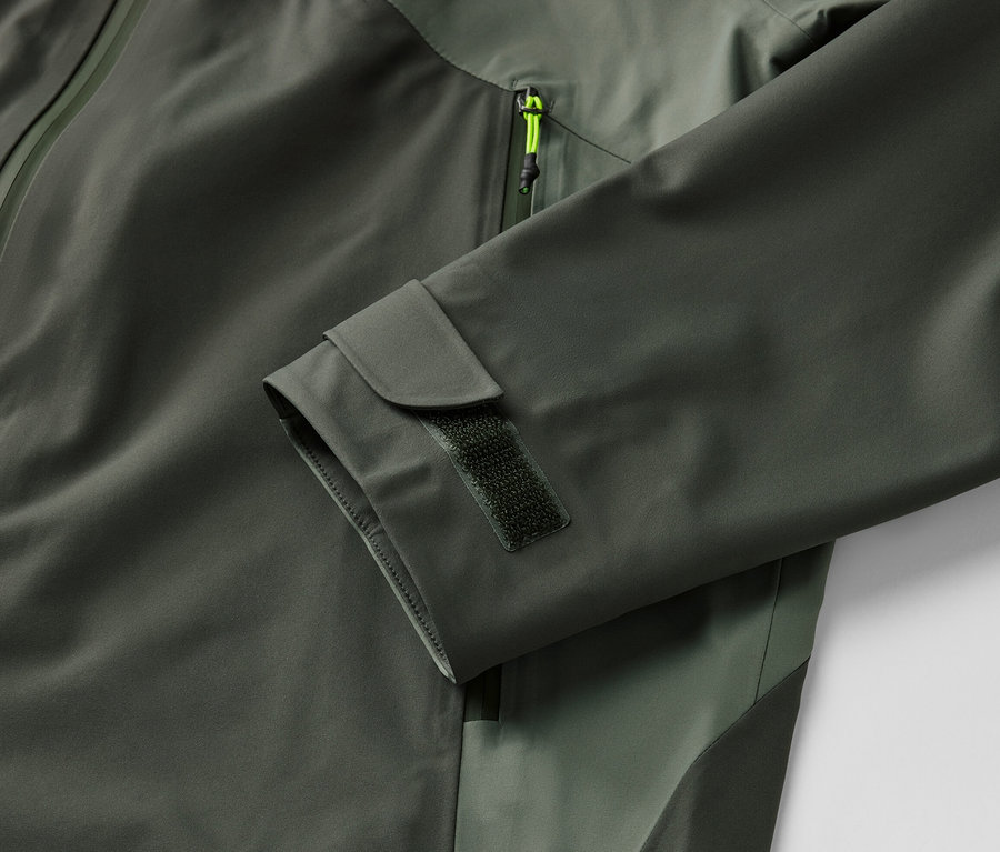 Gros plan sur une veste outdoor 3 couches kaki avec fermeture éclair et manchette.