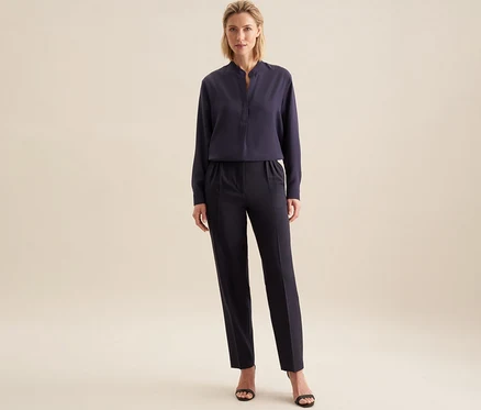 Une femme debout porte une tunique en viscose Seidensticker bleu foncé et un pantalon assorti, avec des sandales noires.