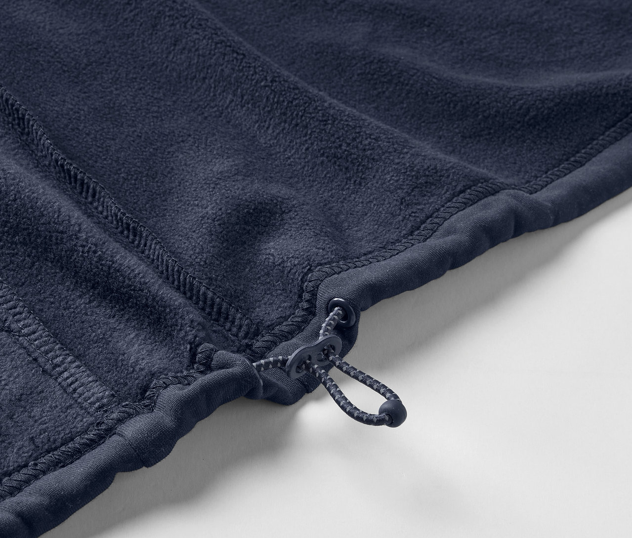 Gros plan sur une veste en polaire bleu marine avec fermeture éclair.