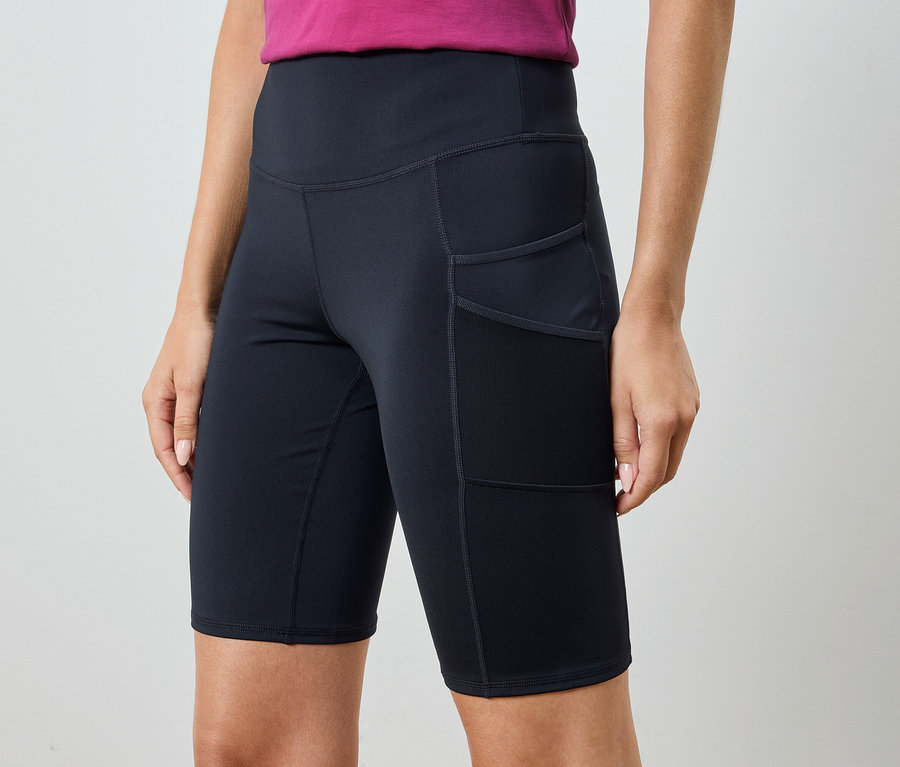 Femme portant un short de sport noir avec poches.
