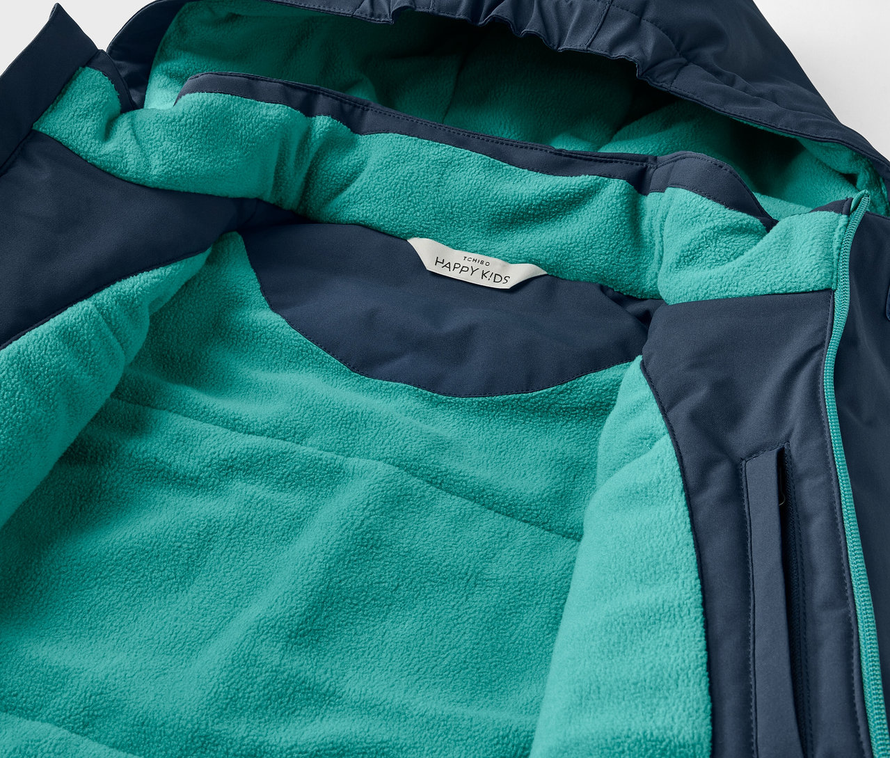Détail d'une veste à capuche, extérieur bleu marine et intérieur turquoise.