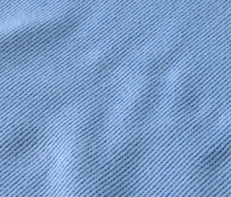 Gros plan d'un tissu bleu clair avec des côtes diagonales.